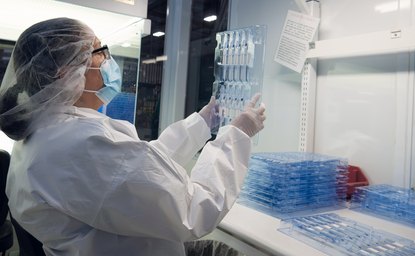 Cleanroom operator inspecting a clear injection-molded tray