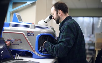 Engineer using a laser welder on a medical device component