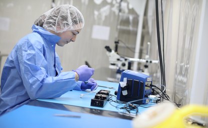 Cleanroom technician assembling medical device components