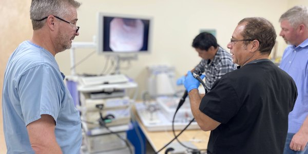 Clinicians and engineers evaluating a flexible endoscope with the scope view on a monitor