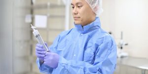 Cleanroom technician inspecting a syringe injection system