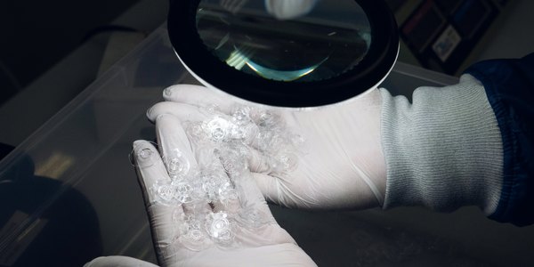 Small clear molded parts inspected under a magnifier