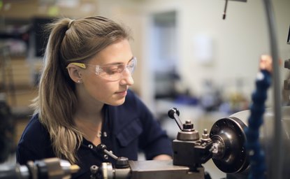 Machinist operating a precision lathe for mold tooling