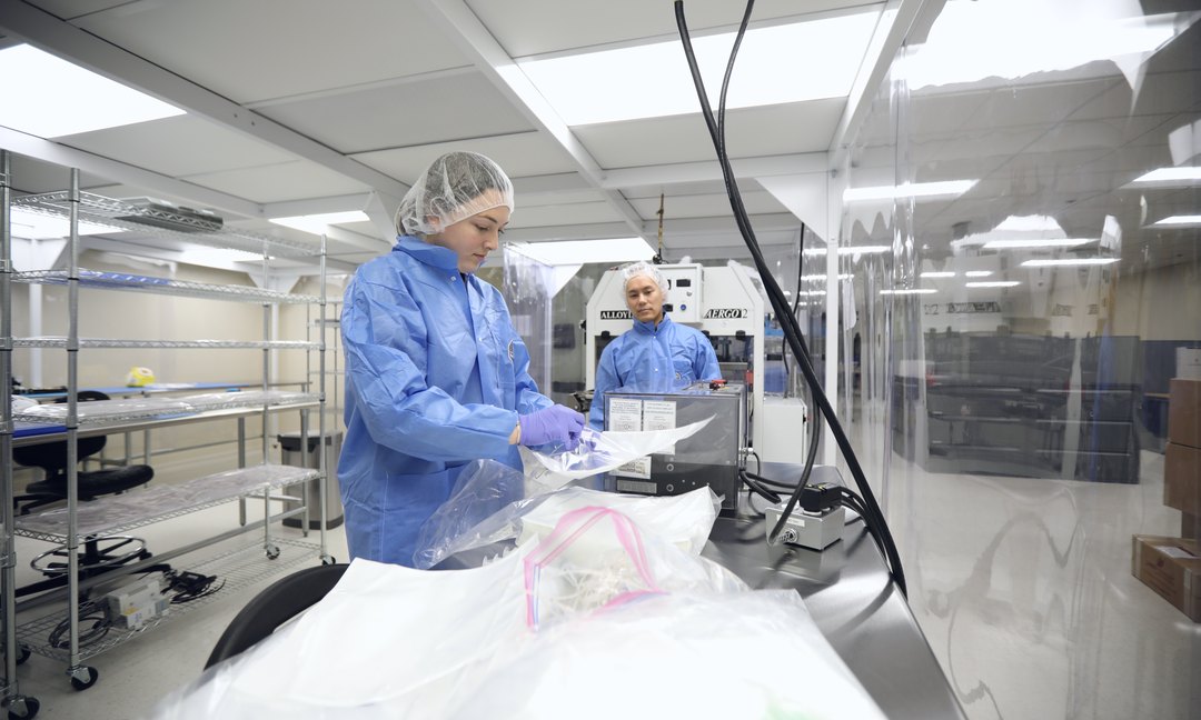 Gowned staff preparing medical product in a cleanroom Gowned staff preparing medical product in a cleanroom